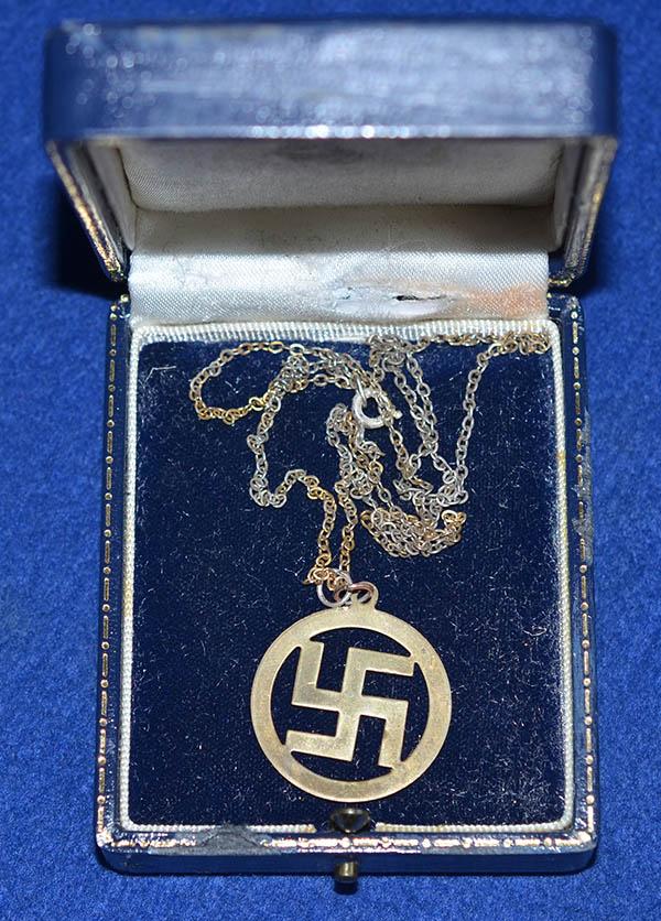 CASED SWASTIKA CIRCULAR PENDANT WITH CHAIN.